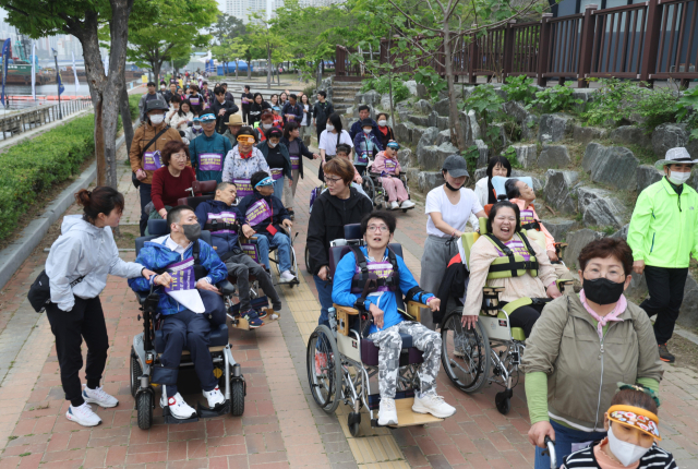 장애인의 날을 맞아 20일 부산 해운대구 APEC 나루공원 일대에서 열린 담쟁이 걷기대회에서 참가자들이 함께 공원을 걷고 있다. 이재찬 기자 chan@